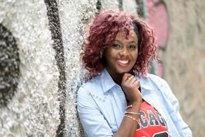 belle femme noire en milieu urbain aux cheveux rouges photo