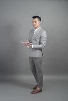 homme d'affaires écrit objectif commercial, fond gris photo