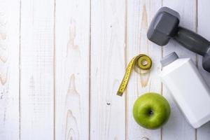 équipement de fitness et aliments santé sur fond de bois blanc photo