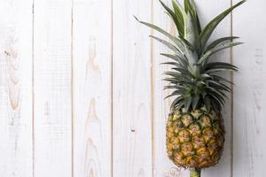 ananas sur fond de bois blanc photo