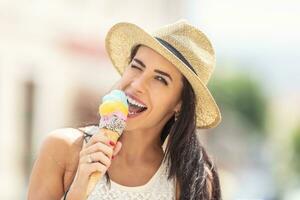 magnifique content femme lèche la glace crème pendant une chaud été journée photo