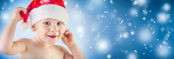 mignonne bébé garçon avec Noël casquette dans abstrait neigeux panoramique bannière photo