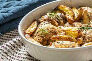 poulet jambes rôti avec américain patates dans cuisson plat photo