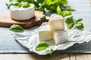 Camembert ou Brie fromage avec basilic feuilles sur table photo