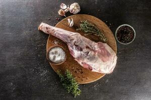 brut agneau jambe avec épices, sel, herbes et Ail. photo
