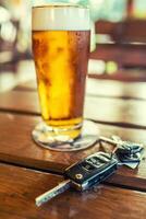 voiture clés et verre de Bière ou distillat de l'alcool sur table dans pub ou restaurant photo