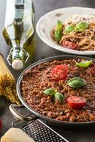 classique italien bolognaise sauce avec Ingrédients Pâtes spaghetti olive pétrole tomates basilic et Parmesan fromage photo