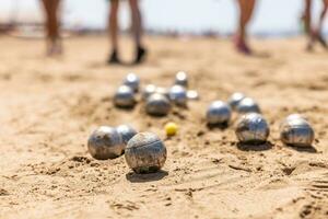 pétanque des balles dans le le sable par le mer pendant une Jeu sur le plage photo