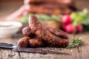 saucisses. fumé saucisses. chorizo saucisses avec légume Romarin épices et cuisine ustensile. photo