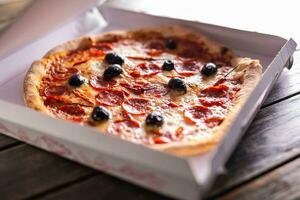 Pizza dans une papier carton boîte sur table prêt à client. photo