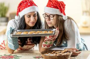 mère et fille prendre plaisir le odeur de fraîchement cuit Noël pain d'épice photo