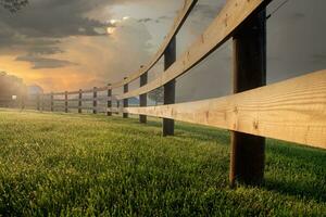 de bonne heure Matin Soleil lumières Divisé rail clôture sur le ferme photo