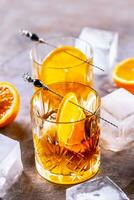 des lunettes de cocktail les boissons vieux façonné avec des oranges et la glace cubes photo