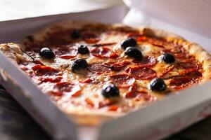 Pizza dans une papier carton boîte sur table prêt à client. photo