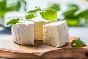 Camembert ou Brie fromage avec basilic feuilles sur table photo