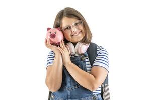 Jeune fille sourit comme elle détient sa tête proche à une rose tirelire avec des économies photo