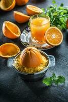 Frais des oranges presse-agrumes jus tropical des fruits et herbes sur béton planche photo