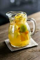 Frais limonade avec divers agrumes dans une plein pot avec Frais coins de fruit à l'intérieur photo