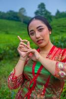 un asiatique femme permanent et posant parmi le thé feuilles photo