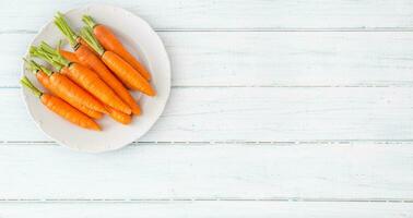Frais carotte sur blanc assiette sur table - Haut de vue photo