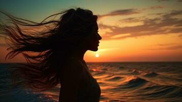 Jeune femme s silhouette contre une le coucher du soleil plus de le mer photo