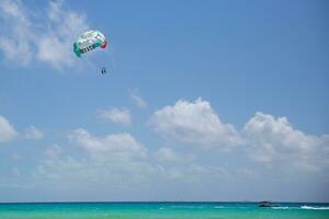 turquiose mer et une paravoile parachute avec signe Mexique et couleurs de le drapeau de cette pays au dessus le Caraïbes mer photo