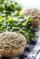 non cuit Lentilles dans en bois quilles avec persil herbes sur cuisine photo