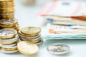 euro billets de banque et pièces de monnaie ensemble sur blanc table - fermer photo