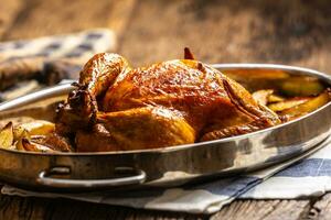 entier cuit d'or croustillant poulet dans une la poêle cuit avec patates photo