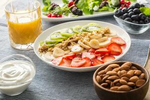 en bonne santé petit déjeuner servi avec assiette de yaourt muesli kiwi des fraises et banane photo