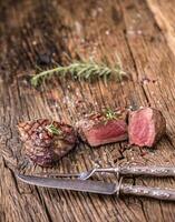 grillé du boeuf steak avec Romarin, sel et poivre sur vieux Coupe planche. du boeuf filet steak. photo