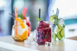 divers limonades dans le maçon pots avec Orange citron vert citron Orange des fraises et Frais fruit des fruits photo