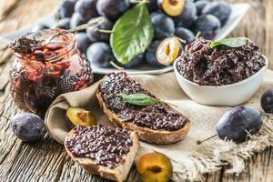 petit déjeuner de fait maison prune confiture pain et mûr prunes. photo