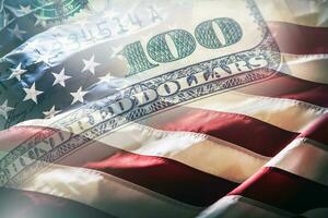 Etats-Unis drapeau et américain dollars. américain drapeau soufflant dans le vent et 100 dollars billets de banque dans le Contexte. photo