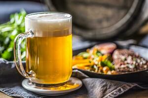 verre de lumière Bière dans pub ou restaurant sur table avec delicoius nourriture photo