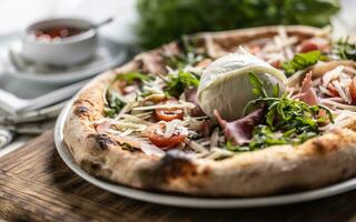 jambon, la roquette, tomates et fromage Pizza avec tout mozzarella di bufala campana sur Haut photo