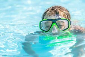 enfant nager dans une bassin avec des lunettes de protection sur photo