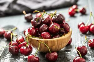 Frais cerises lavé dans nettoyer l'eau dans une bol et épars tout autour photo