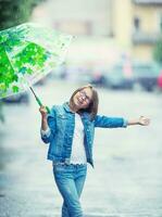 portrait de magnifique Jeune pré-ado fille avec parapluie en dessous de pluie photo