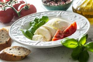 mozzarella fromage tomates basilic et olive huile. caprese salade - italien ou méditerranéen repas ou apéritif photo