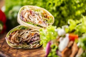 tortilla enveloppements avec Viande, légumes, Mayonnaise avec une salade sur le côté photo