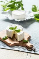 Camembert ou Brie fromage avec basilic feuilles sur table photo