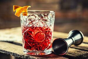 cocktail negroni sur une vieux en bois planche. boisson avec Gin, Campari martini Rosso et Orange photo