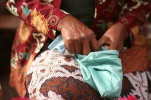 un vieux femme est prise en dehors argent de une traditionnel tissu sac. photo