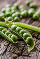 petits pois. Frais bio fait maison pois et dosettes sur vieux chêne planche. en bonne santé Frais vert légume - pois et gousses. photo