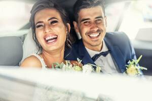 content jeunes mariés rire ensemble dans le voiture après leur mariage journée est plus de photo