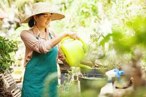 une femme arrosage les plantes dans une jardin photo
