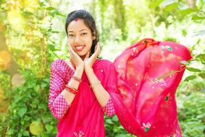 une femme dans une rose sari souriant photo