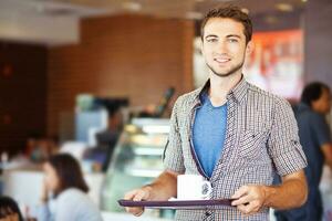 une homme en portant une plateau avec une tasse de café photo