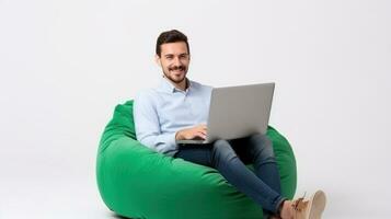 de bonne humeur homme travail sur portable assise sur une vert pouf photo